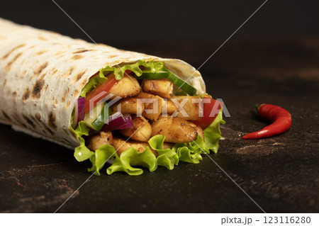 Shawarma, Doner kebab. Shawarma chicken roll with vegetable salad. Chicken wraps. Side view. Stone background. Shawarma, Doner kebab. Shawarma chicken roll with vegetable salad. Chicken wraps. Side view. Stone background. 123116280