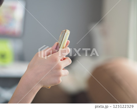 スマホの画面を見る子供の手元 スマホの画面を見る子供の手元 123122329