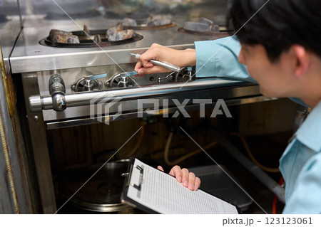 飲食店のガスコンロを確認する男性 123123061