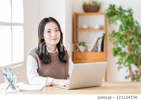 リビングでテレワークをする若い女性。 リビングでテレワークをする若い女性。 123124556