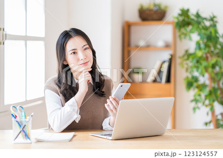 リビングでテレワークをする若い女性。 リビングでテレワークをする若い女性。 123124557
