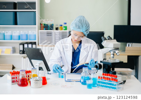 female scientist working with micro pipettes analyzing biochemical 123124598