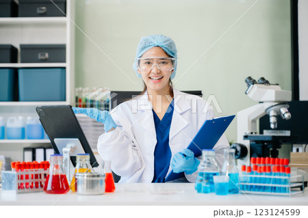 female scientist working with micro pipettes analyzing biochemical female scientist working with micro pipettes analyzing biochemical 123124599