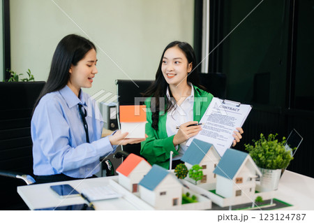 balancing the property sector The real estate agent is explaining the house style to see the house design balancing the property sector The real estate agent is explaining the house style to see the house design 123124787