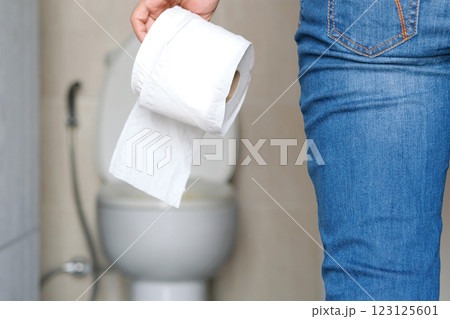 Man's hand, he holds a roll of toilet paper Going to the bathroom Toilet toilet background Man's hand, he holds a roll of toilet paper Going to the bathroom Toilet toilet background 123125601