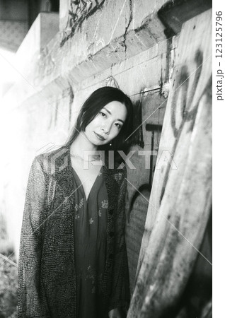 高架下の落書きの前でポーズをとる女性 123125796