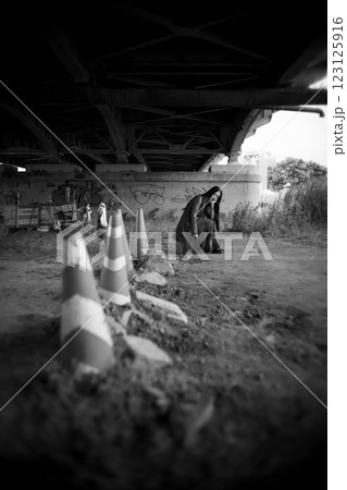 高架下の現場でポーズをとる女性 123125916