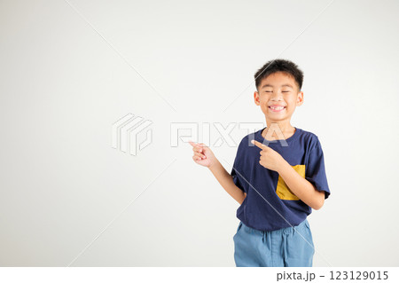 Happy Asian portrait cute young kid boy smiling indicate finger empty space, studio shot isolated on white background, Thai primary child pointing index out with copy space Happy Asian portrait cute young kid boy smiling indicate finger empty space, studio shot isolated on white background, Thai primary child pointing index out with copy space 123129015