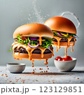 An impressive double-decker burger stacked with fresh lettuce, onions, cheese, and dripping sauce, with ingredients flying dramatically in the background, creating an exciting food explosion. 123129851