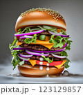 An impressive double-decker burger stacked with fresh lettuce, onions, cheese, and dripping sauce, with ingredients flying dramatically in the background, creating an exciting food explosion. 123129857