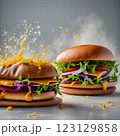 An impressive double-decker burger stacked with fresh lettuce, onions, cheese, and dripping sauce, with ingredients flying dramatically in the background, creating an exciting food explosion. 123129858