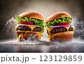An impressive double-decker burger stacked with fresh lettuce, onions, cheese, and dripping sauce, with ingredients flying dramatically in the background, creating an exciting food explosion. 123129859