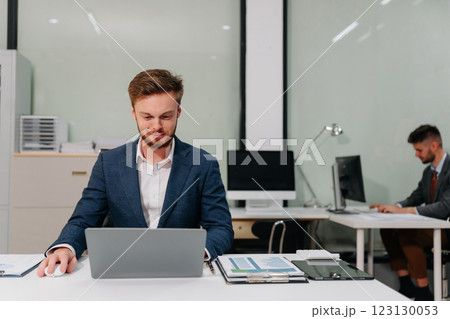 Business man working at office with laptop and documents on desk, financial adviser analyzing data. Business man working at office with laptop and documents on desk, financial adviser analyzing data. 123130053