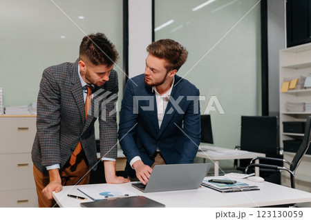 Diverse professionals collaborate on project analysis with financial graphs. Diverse professionals collaborate on project analysis with financial graphs. 123130059