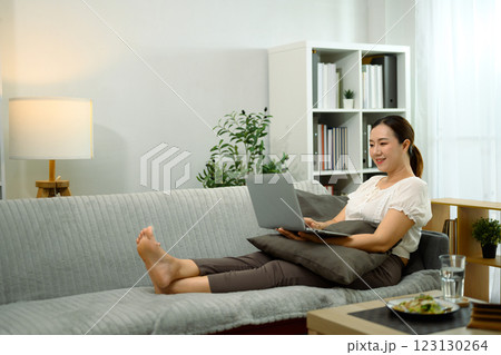Smiling middle aged woman using her digital tablet to browse or watch content 123130264