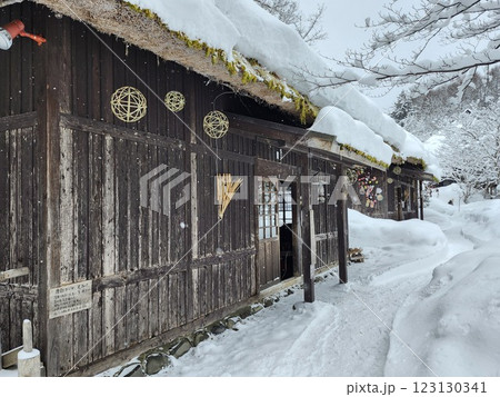 前日に降った雪で屋根に積もった茅葺屋敷 123130341