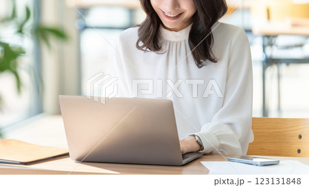 ノートパソコンを使う笑顔の女性・ビジネスウーマン ノートパソコンを使う笑顔の女性・ビジネスウーマン 123131848