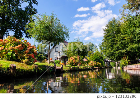 Scenic view of green riverside garden house german national park Spreewald on spring summer sunny day . Spree river forest greenery canal nature tranquil landscape in Germany blue sky background 123132290