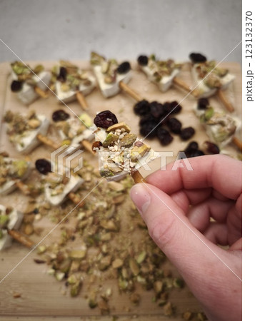 Chef preparing delicious christmas tree canapes with cheese, pistachios, cranberries, and sesame seeds on salty sticks in prague, czechia. Ideal for parties, buffets, and stylish aperitifs 123132370