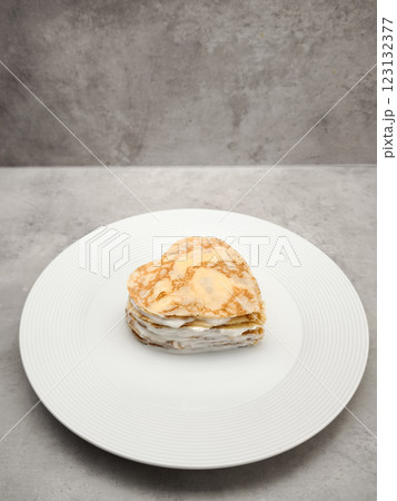 Heart shaped crepes cake layering white yogurt, sitting on white plate, symbolizing romantic love and culinary artistry for Mother's Day Valentines copy space Heart shaped crepes cake layering white yogurt, sitting on white plate, symbolizing romantic love and culinary artistry for Mother's Day Valentines copy space 123132377