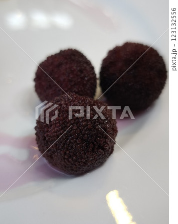 Three ripe red bayberries resting on white plate all you can eat 123132556