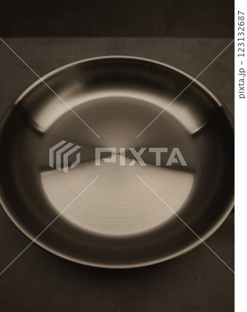 Stainless steel frying pan is waiting on a kitchen countertop, ready to be used for cooking, close up 123132687
