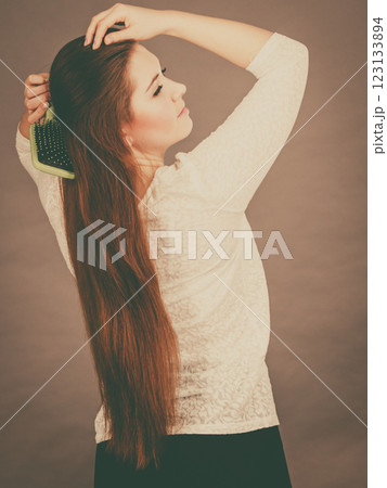 Happy woman brushing her hair Happy woman brushing her hair 123133894