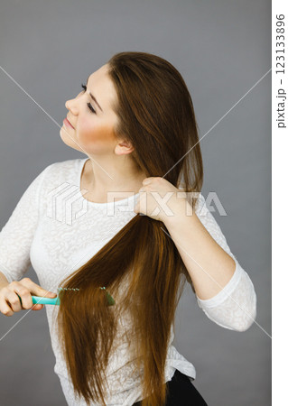 Happy woman brushing her hair Happy woman brushing her hair 123133896