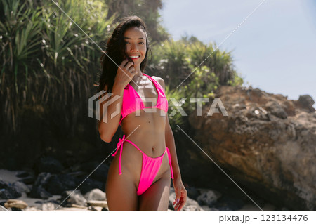 Portrait of smiling woman in a bikini enjoying a sunny beach day Portrait of smiling woman in a bikini enjoying a sunny beach day 123134476