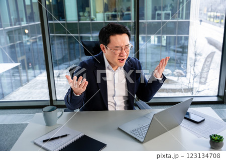 Frustrated Businessman Facing Challenges in Modern Office Environment 123134708