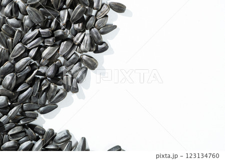 Black Unpeeled Sunflower Seeds on White Background, Place for Text, Top View Black Unpeeled Sunflower Seeds on White Background, Place for Text, Top View 123134760
