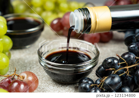 Balsamic vinegar pour from a glass bottle into a bowl 123134800