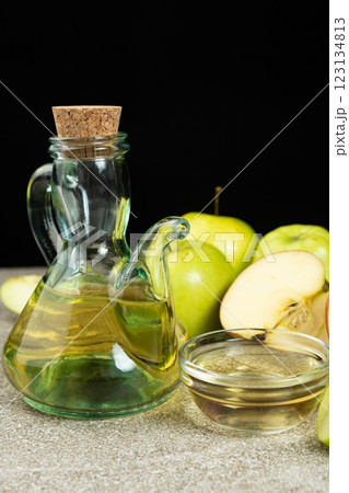 Apple cider vinegar in a glass vinegar bowl among apples Apple cider vinegar in a glass vinegar bowl among apples 123134813