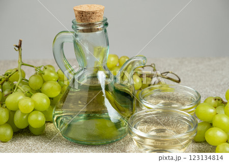 White wine vinegar in a vinegar bowl among grapes White wine vinegar in a vinegar bowl among grapes 123134814