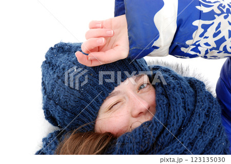Winter joyful woman winking in cozy blue hat and scarf 123135030