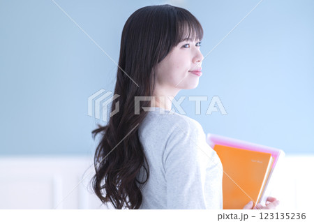 ノートとファイルを持つ若い女子学生 ノートとファイルを持つ若い女子学生 123135236