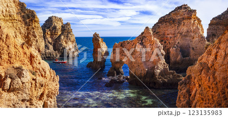 Amazing rocky scenic becahes of Algarve coast, Portugal. Breathtaking yellow rocks with arc .   123135983