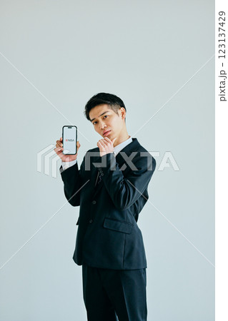 スマホを持つ20代の若い男性　新NISA 123137429