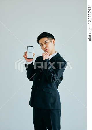 スマホを持つ20代の若い男性 iDeCo スマホを持つ20代の若い男性 iDeCo 123137434