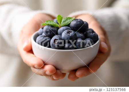 Blueberries in bowl holding by woman hand, Healthy fruit, Food ingredient 123137566