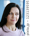 Pretty brunette woman 51 years old with light pink makeup looks to the side 123139595