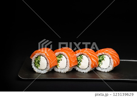 Delicious Fresh Salmon Sushi Rolls Presenting Exquisitely on a Black Background Delicious Fresh Salmon Sushi Rolls Presenting Exquisitely on a Black Background 123139629