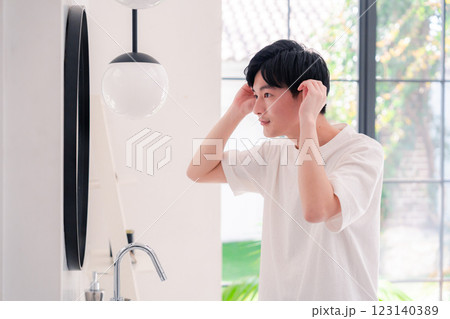 洗面所で身だしなみを整える若い男性 123140389