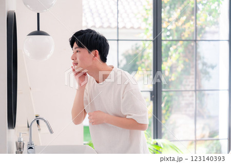洗面所で身だしなみを整える若い男性 123140393