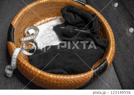 The beginning of the process of knitting a black sweater in a basket. The beginning of the process of knitting a black sweater in a basket. 123140556