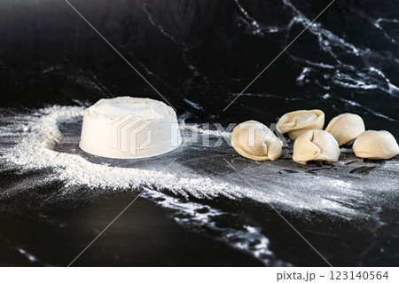 Raw meat dumplings in a green pot on a dark background. Selective focus. 123140564