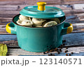 Raw dumplings in a blue bowl on a wooden background. 123140571