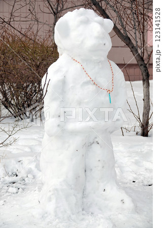 Cool snowman on the street near the house, sculpted with a lion's head 123141528