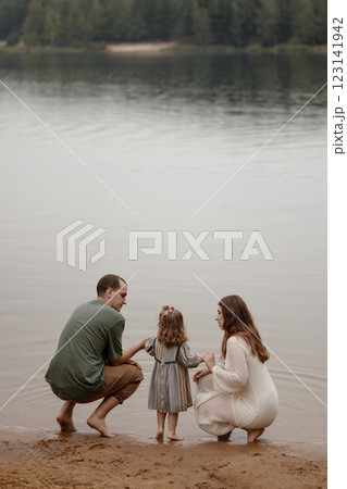 Family spending quality time by a calm lake.  123141942