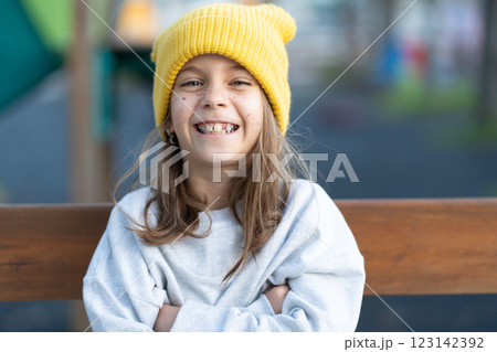 Cheerful girl in yellow cap with freckles sitting Cheerful girl in yellow cap with freckles sitting 123142392